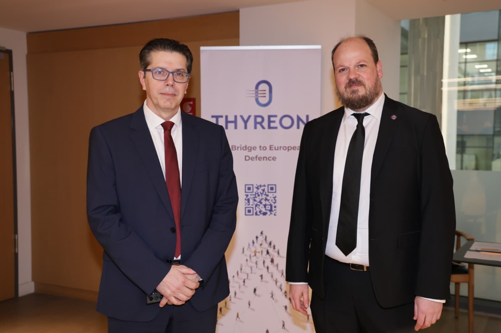 Konstantinos Michanetzis and Sotiris Kokkinos in front of the THYREON "Bridge to European Defence" banner